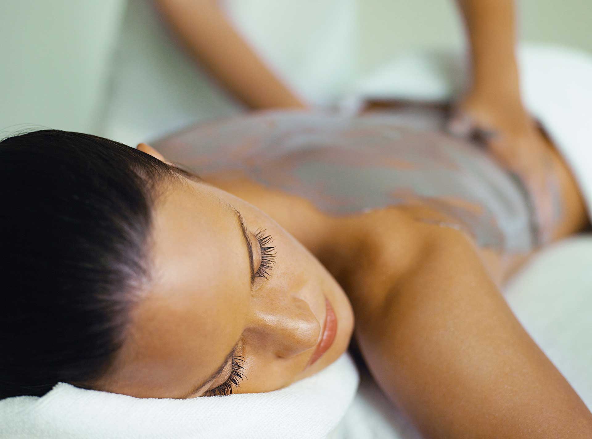 a woman receiving a mud massage